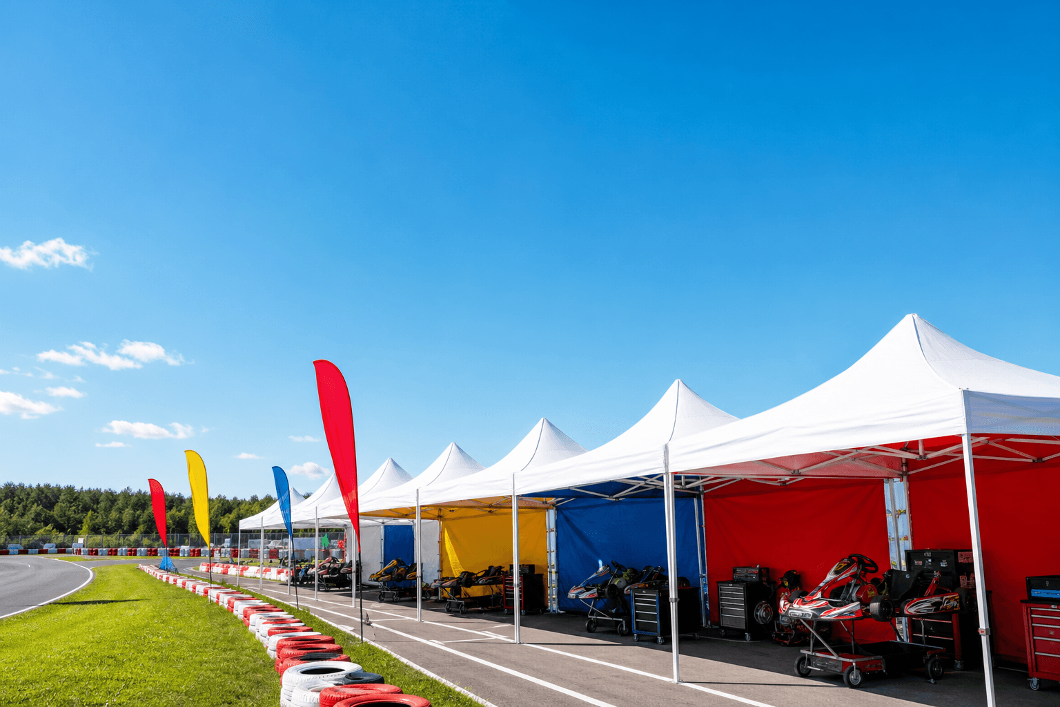 晴れたサーキットに並ぶ EIKO INSTANT CANOPY のワンタッチテント